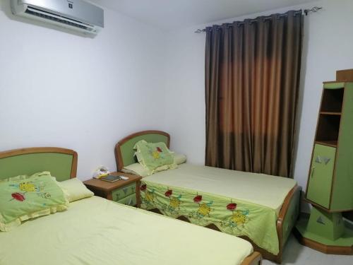 a room with two beds and a dresser in it at دلتا مارينا in Al Ḩammād