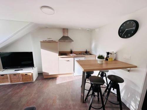 une cuisine avec une table et une horloge au mur dans l'établissement Lakanal 10 - Appart Prébendes Tours, à Tours