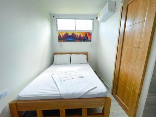 ein kleines Bett in einem Zimmer mit Fenster in der Unterkunft Apartamento Villa Carolina 102 in Coveñas