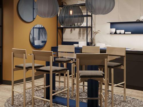 - une salle à manger avec une table, des chaises et des miroirs dans l'établissement Mercure Annecy Centre, à Annecy