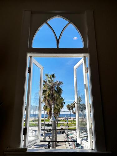 uma janela aberta com vista para uma palmeira em Samesun Venice Beach Hotel & Hostel em Los Angeles