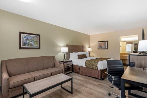 une chambre d'hôtel avec un lit et un canapé dans l'établissement Best Western Brenham, à Brenham
