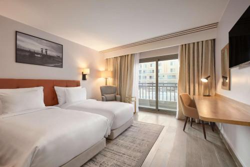 開羅的住宿－Radisson Residences Cairo Heliopolis，酒店客房配有两张床和一张书桌