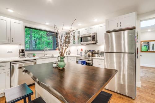 a kitchen with a table and a refrigerator at Sawyer Retreat with Fire Pit Less Than 2 Mi to Beaches! in Sawyer