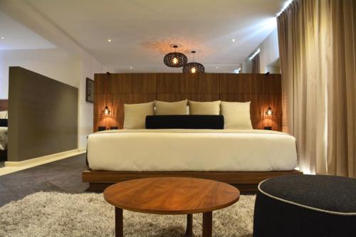 a bedroom with a large bed and a table at Ilo Rojo Hotel Boutique in San Miguel de Allende