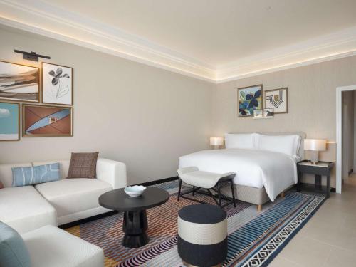 a hotel room with a bed and a couch at Sofitel Al Hamra Beach Resort in Ras al Khaimah