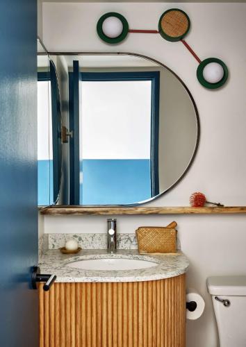 a bathroom with a sink and a mirror at Wayfinder Waikiki - Voted Top 10 Best Hotels in Hawaii! in Honolulu