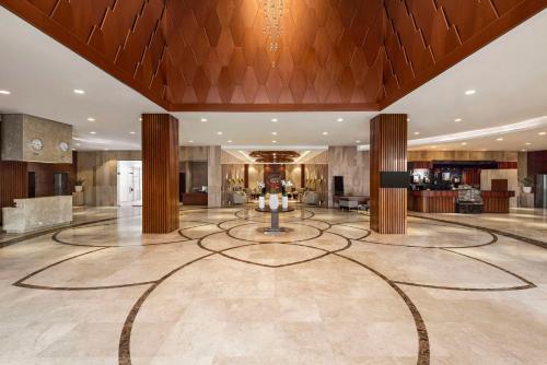- un hall avec une grande pièce munie d'une table dans l'établissement Radisson Hotel Muscat Panorama, à Mascate