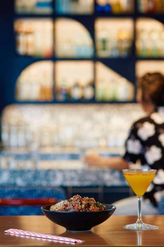 a bowl of food and a drink on a table at Wayfinder Waikiki - Voted Top 10 Best Hotels in Hawaii! in Honolulu