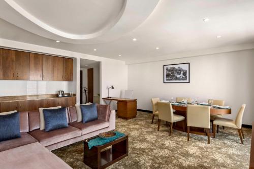 a living room with a couch and a table at Radisson Hotel Muscat Panorama in Muscat