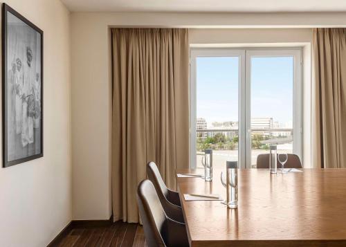 a dining room with a table and a large window at Radisson Hotel Muscat Panorama in Muscat