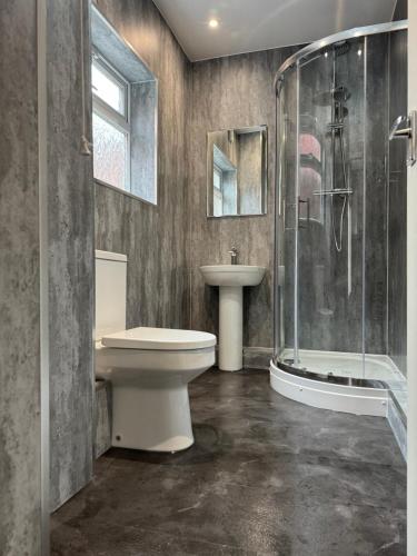 a bathroom with a toilet and a sink and a shower at Deluxe Inn Gateshead in Gateshead