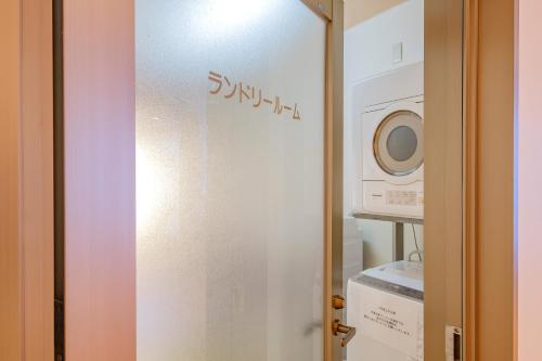 阿蘇CANYON TERRACE＆LODGE في كوروغاوا: باب زجاجي في مطبخ مع غسالة ملابس