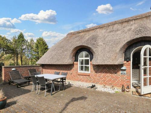 a brick house with a table and chairs outside at 6 person holiday home in Jerup-By Traum in Jerup