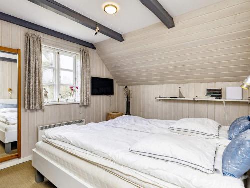 a large white bed in a room with a window at 6 person holiday home in Jerup-By Traum in Jerup