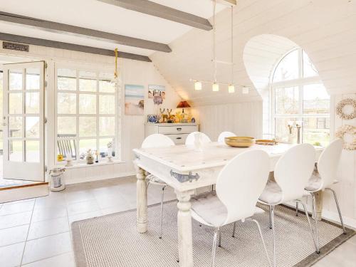 a white kitchen with a white table and white chairs at 6 person holiday home in Jerup-By Traum in Jerup