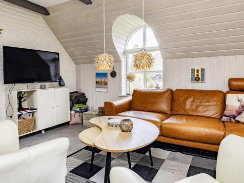 a living room with a leather couch and a table at 6 person holiday home in Jerup-By Traum in Jerup
