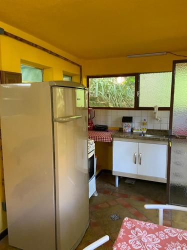 - une cuisine équipée d'un réfrigérateur au milieu d'une pièce dans l'établissement Chalé Laranja - Sítio Caldeirão, à Posse