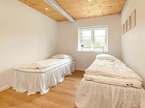 Duas camas num quarto com uma janela em Holiday home Læsø IV em Læsø