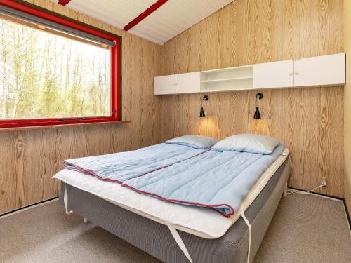 1 dormitorio con 1 cama en una pared de madera en Holiday home Læsø XXV en Læsø