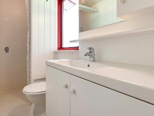 biała łazienka z umywalką i toaletą w obiekcie Holiday home Læsø XXV w mieście Læsø