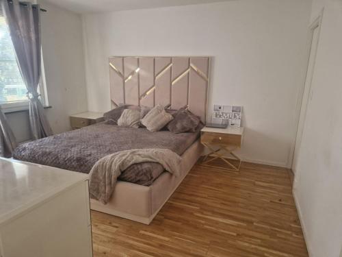 a bedroom with a large bed and a wooden floor at Jahminatu`s Apartment in Södertälje