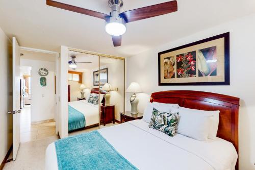 une chambre avec deux lits et un ventilateur de plafond dans l'établissement Kahana Reef 211, à Kahana