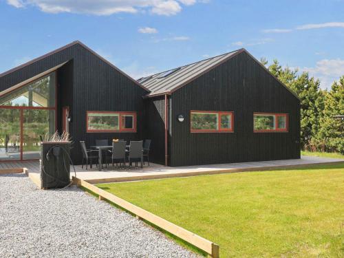 a black house with a table and chairs in front of it at 10 person holiday home in Jerup-By Traum in Jerup