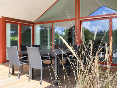 a dining room with a table and chairs on a deck at 10 person holiday home in Jerup-By Traum in Jerup