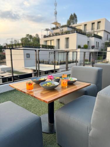a wooden table with bowls of food on a balcony at Ilo Rojo Hotel Boutique in San Miguel de Allende