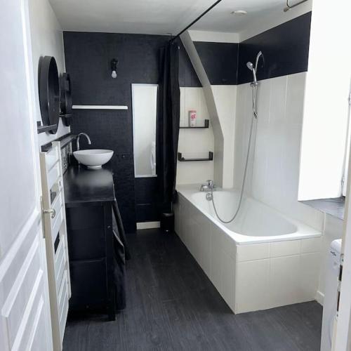 une salle de bain avec une baignoire et un lavabo et une baignoire dans l'établissement Duplex chaleureux, à Corbeil-Essonnes