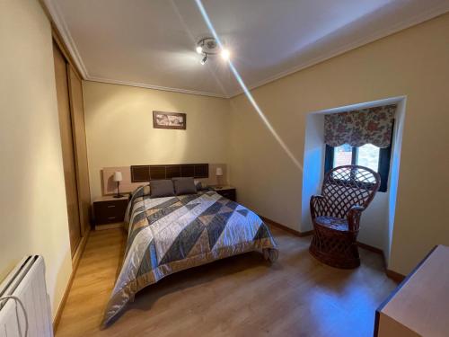 a bedroom with a bed and a chair in it at Casa rural Herminia in Ourense