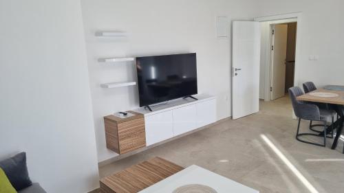 a living room with a flat screen tv on a wall at Villa SHARK 2 with a pool in Novalja