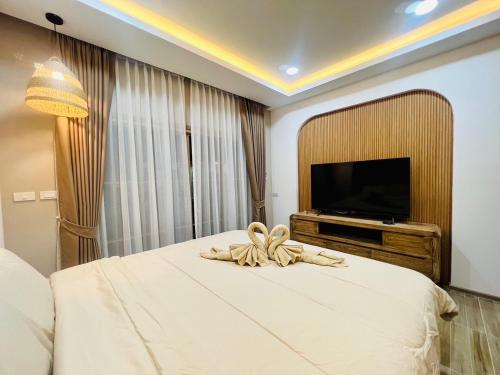 a bedroom with a large bed with a television on it at Villa De Phawa in Samut Songkhram