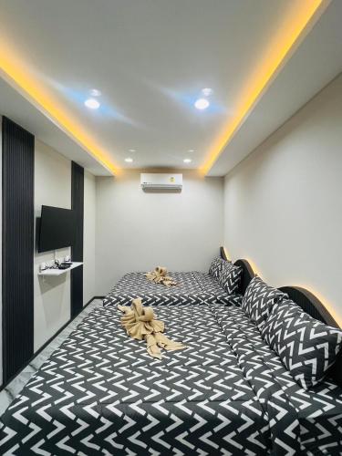 a bedroom with a bed with a black and white comforter at Villa De Phawa in Samut Songkhram