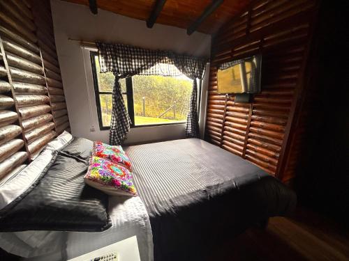 a small room with a bed and a window at Hermosa Cabaña de campo Selah in Tabio