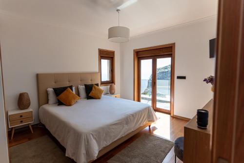 - une chambre avec un lit blanc et une fenêtre dans l'établissement GALVÃO HOUSE EXPERIENCE, à Ribeira Brava