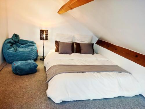1 dormitorio con 1 cama y 1 reposapiés azul en Villa Paris et parc d'expostions stade de France, en Aulnay-sous-Bois
