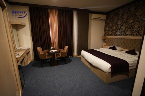 a hotel room with a bed and a desk at Hotel Seever in Erbil