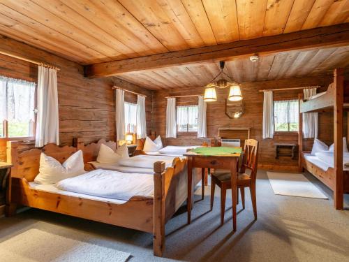 - une chambre avec 4 lits et une table dans l'établissement Alpin Hideaway L, à Wörgl