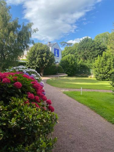 een tuin met bloemen en een huis op de achtergrond bij Charmant Duplex Trouville-Deauville in Trouville-sur-Mer