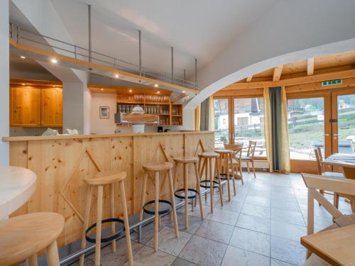 a bar in a restaurant with wooden counters and stools at Mooshäusl Large in Hopfgarten im Brixental
