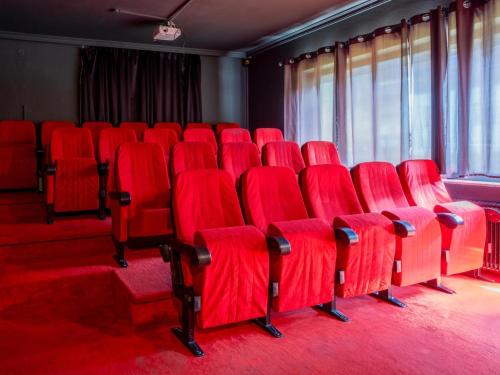 a row of red chairs in a room at Mooshäusl Large in Hopfgarten im Brixental