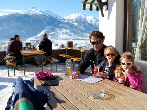 a man and two children sitting at a table at Appartementhaus Sonnenhang in Ehrwald