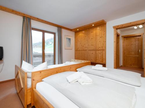 two beds in a room with a window at Mooshäusl in Hopfgarten im Brixental