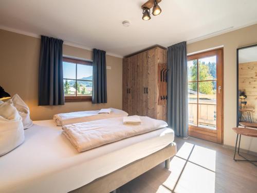 a bedroom with a large bed and a window at Chalet Sonnenalp in Hopfgarten im Brixental