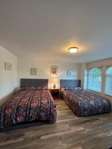 een slaapkamer met 2 bedden en een tafel met een lamp bij Beautiful Home in Burnaby (Metrotown Area) in Burnaby