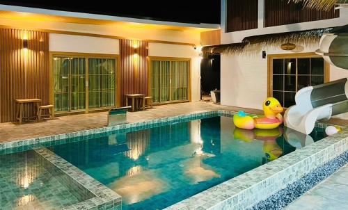 a swimming pool with a slide in a house at Villa De Phawa in Samut Songkhram
