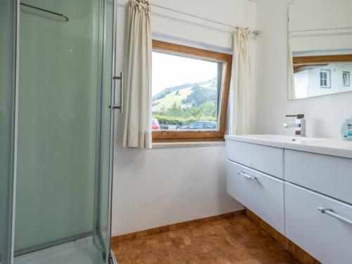 a bathroom with a shower and a sink and a window at Gaisbergblick XXL in Kirchberg in Tirol