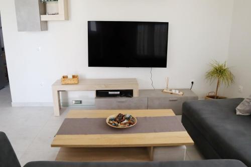 a living room with a coffee table and a flat screen tv at Aelia Summer House in Samos